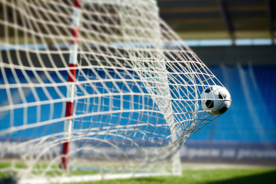 ballon de foot tiré dans un filet des cage