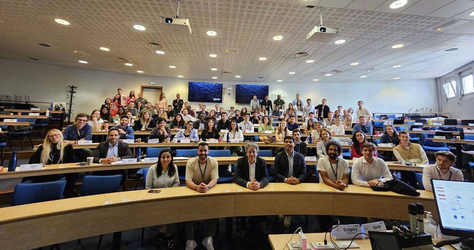 Grande salle de classe ou d'amphithéâtre remplie d'étudiants avec un professeur