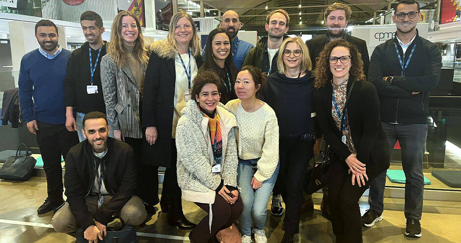 a group of people, likely employees or colleagues, posing together for a group photo. 